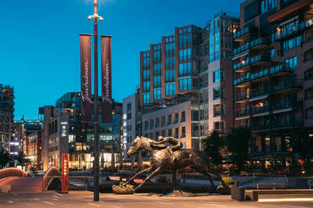 Oslo, Norway. Night View Of Horse Statue On The Street And Residential Multi-storey Houses In Aker Brygge District. Summer Evening. Famous Modern Residential Areaのeditorial素材