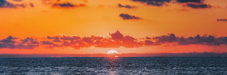 Panorama Of Sundown Over Sea Horizon At Sunset. Natural Sunrise Sky Warm Colors Over Ocean.の写真素材