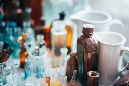 Many Old Medical  Glass Capacity. Detail Of Retro Chemical Pharmaceutical Science Researches. Many Small Vintage Bottles And Glassware Different Sizes And Colors.の写真素材