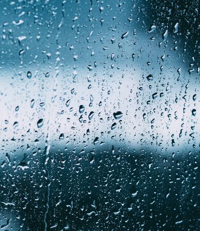Drops Of Water Or Rain On Wet Glass Background. Moody Photo In Cold Blue Color.の写真素材