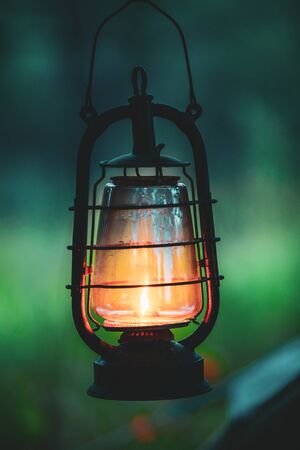 Old German Wehrmacht Times Of World War II Vintage Lantern With Burning Kerosene Wick Hanging On Camp In Summer Forest.の写真素材