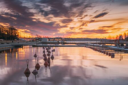 Helsinki, Finland. Landscape With City Pier, Jetty At Winter Sunrise Or Sunset Time. Tranquil Sea Water Surface At Early Morningの写真素材