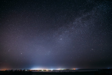 Night Starry Sky With Glowing Stars Above Landscape With City Lights. Dark Night Starry Sky Above...