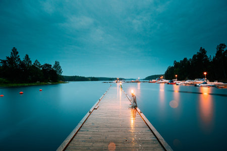 Sweden. Beautiful Wooden Pier Near Lake In Summer Evening Night. Lake Or River Landscape. Riverside