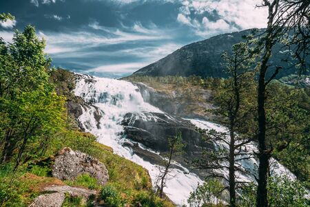 Kinsarvik, Hordaland, Norway. Waterfall Nyastolfossen In Hardangervidda Mountain Plateau. Nyastolsfossen in Spring Sunny Day. Height Of 115 m. Norwegian Landmark And Popular Destinationの写真素材
