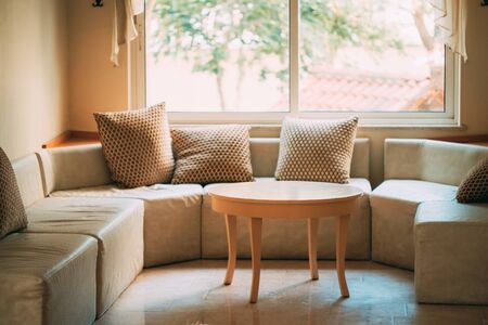 Table and sofa near window in lobby. Upholstered furniture.の写真素材