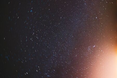 Real Night Sky Stars Background With Natural Colourful Sky Gradient. Rotation Of Starry Sky. Yellow And Magenta Colors.の写真素材