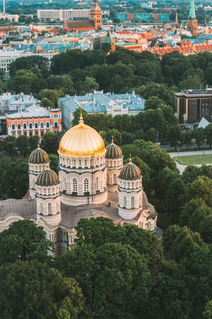 Riga, Latvia - July 2, 2016: Riga Cityscape. Top View Of Riga Nativity Of Christ Cathedral - Famous Church And Landmark In Summer Evening. Golden Yellow Domes.のeditorial素材