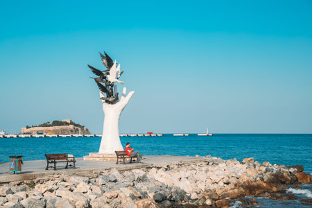 Kusadasi, Aydin Province, Turkey - September 9, 2019: Man Sitting on bench near Hand Of Peace...