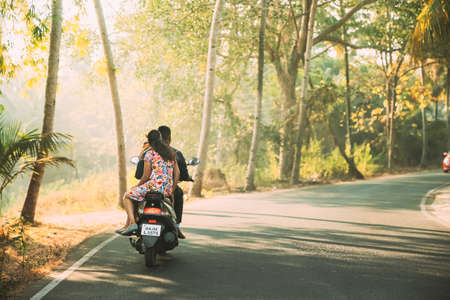 Margao, Goa, India - February 16, 2020: People Riding On Scooters Motorcycle On Road In Sunny Light.のeditorial素材
