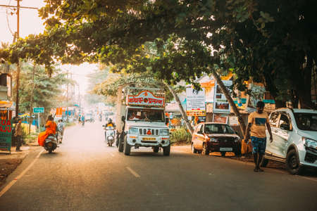 Goa, India - February 13, 2020: Truck And Scooters Motorcycles Moving On Street In Sunny Summer Dayのeditorial素材