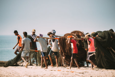 Arossim, Goa, India - February 18, 2020: Fishermen Lay Out Nets To Twist Them