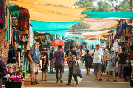 Anjuna, Goa, India - February 19, 2020: Musical Instrument Seller Sells Traditional Indian Flutes To A Tourist In The Anjuna Market.のeditorial素材