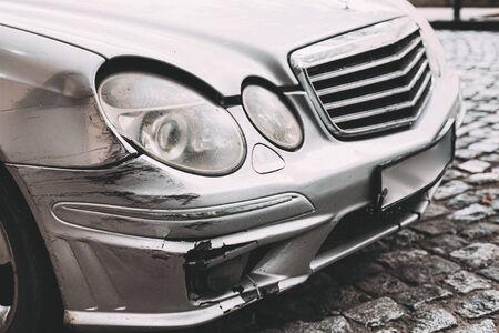 Broken Bumper Luxury Car Scratched With Deep Damage To Paint. Abandoned Car After Accident In City Streetの写真素材
