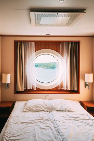 Ship Cabin With Bed And Window With View On Sea. Luxury Cabin On Ferry Boat Or Cruise Linerの写真素材