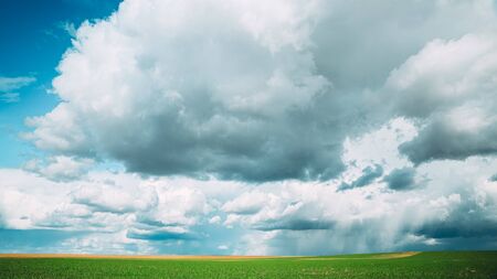 Amazing Natural Bright Dramatic Sky With Rain Clouds Above Countryside Rural Field Meadow Landscape In Spring Summer Cloudy Day. Scenic Sky With Fluffy Clouds On Horizon. Beauty In Nature.の写真素材