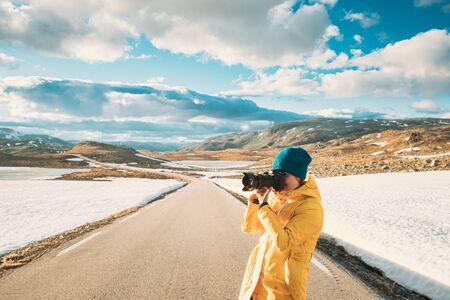 Aurlandsfjellet, Norway. Young Happy Woman Tourist Traveler Photographer Taking Pictures Photos Of Aurlandsfjellet Scenic Route Road. Norwegian Landmark And Popular Destinationの写真素材