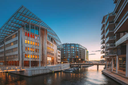 Oslo, Norway. Night View Embankment And Residential Multi-storey Houses In Aker Brygge District. Summer Evening. Residential Area Reflected In Sea Waters. Famous And Popular Placeの写真素材