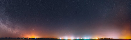 Night Starry Sky With Glowing Stars Above Countryside Landscape. Milky Way Galaxy And Rural Field...