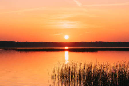 Sundown Above Lake River Horizon At Sunset. Natural Sky In Warm Colors Water. Sun Watersの写真素材