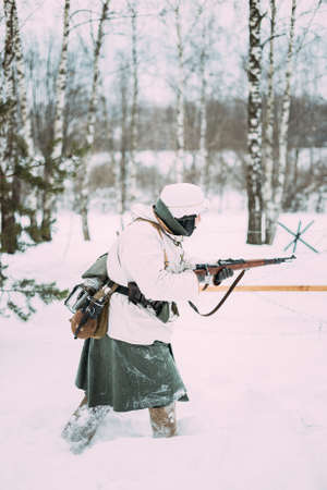 German Wehrmacht Infantry Soldier In World War II Attacking With Rifle In Winter Day. Historical Re-enactment. WWII.の写真素材