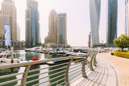 Yachts are moored at city pier, jetty in Dubai Marina in sunny summer day. Cityscape skyline. Urban backgroundの写真素材