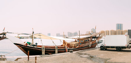 Dhow, sailboat, sailing vessel boat is moored to the city pier, jetty. Truck parked to city pier....