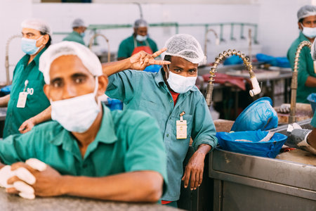 Ajman, UAE, United Arab Emirates - May 26, 2021: Men cleaning fresh fish at fish market in Ajman. Ajman fish market. Men clean fresh fish at fish market. People worker at fish marketのeditorial素材