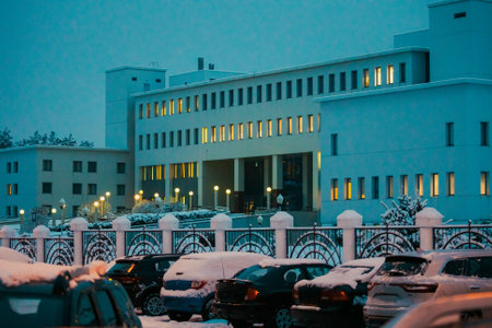 View of building of medical hospital on a winter evening. ars are parked in front of the medical center in winter seasonの写真素材