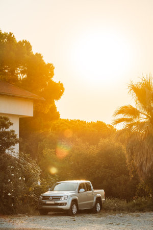 Gray Volkswagen Amarok pickup truck parked in countryside during summer sunset.のeditorial素材