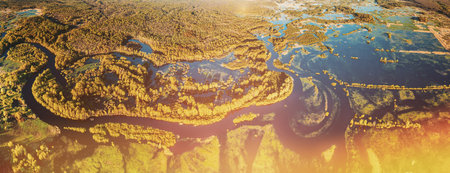 Aerial View Green Forest Woods And River Landscape In Sunny Spring Summer Day. Top View Of Nature, Bird's Eye View. Trees Standing In Water During Spring Flood floodwaters. woods in Water deluge During A Spring Flood. Beautiful spring landscape with inundation river.の写真素材