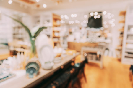 Home accessories and household products for dining room in store of shopping centre. View of beautifully set table. Home accessories of dinnerware on table in shop fashion retail store. Abstract blur blurred boke bokeh background.の写真素材