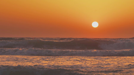 Sun Shine Above Sea During calm Sunset. Natural Warm Colors Over Ripple Sea With Waves. Ocean Wave Water Foam Splash Washing Sandy Beach At Sunset. Sundown Vacation Backgroundの写真素材