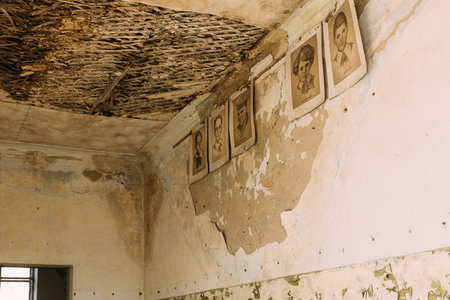 Six Black And White Paper Portraits Of Young Pioneers, Heroes Of WW2 War On Cracked Peeling Wall In Classroom Of Abandoned School After Chernobyl Nuclear Disaster In Evacuation Zone.の写真素材