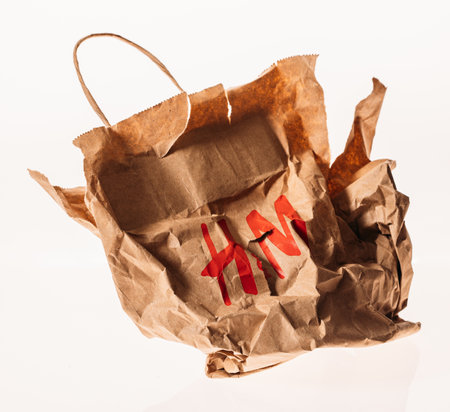 Paris, France. - January 16, 2023: Close-up view on Crumpled Brown Shopping H&m Paper Bag Isolated On White. Used Craft Paper Shopping Bag. Recycled Paper Grocery Bag. Concept Of Recyclingのeditorial素材