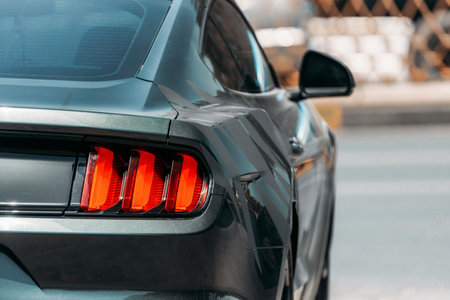 Dubai, UAE, United Arab Emirates - May 25, 2021: Headlight Of Black Color Ford Mustang Car Parked At Street. Back View. Ford Mustang is series of American automobiles manufactured by Ford. High quality photoのeditorial素材