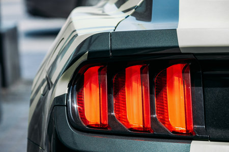 Dubai, UAE, United Arab Emirates - May 25, 2021: Close Up Headlight Of Black Color Ford Mustang Car Parked At Street. Back View. Ford Mustang is series of American automobiles manufactured by Ford. High quality photoのeditorial素材