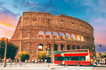 Rome, Italy. Amazing Scenic View Colorful Sky Above Colosseum. Red Hop On Hop Off Touristic Bus For Sightseeing In Street Near Flavian Amphitheatre. Famous World Landmark. City Sightseeing Tourの写真素材