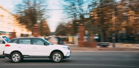 White Geely Boyue (Geely Atlas) Car Fast Rides City Street. Side View. The Geely Boyue Is A Compact Crossover Suv Produced By The Chinese Automaker Geelyのeditorial素材