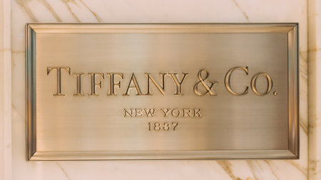 Dubai, UAE, United Arab Emirates - May 28, 2021: Close golden logotype Tiffany Co is an American luxury jewelry and specialty retailer headquartered in New York City. Tiffany is known for its luxury goods, particularly its diamond and sterling silver jeweのeditorial素材