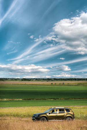 AWD 4WD SUV green car in summer meadow landscapeの写真素材