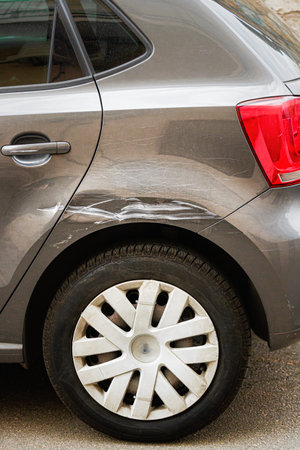 Broken Scratched Rear Fender Car. Scratched With Deep Damage To Paint. Close Up car with a damaged...