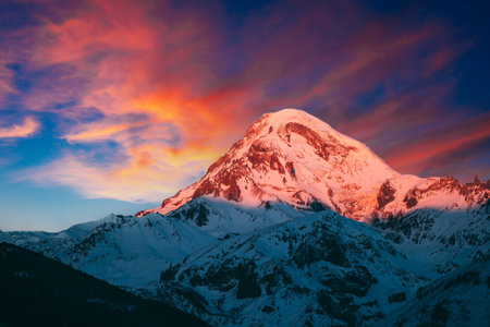 Georgia. Mount Kazbek Covered Snow In Winter Sunrise. Morning Dawn Colored Top Of Mountain In...