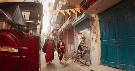 New Delhi, Delhi, India. Women wearing traditional dresses saris walking On narrow Street.のeditorial素材
