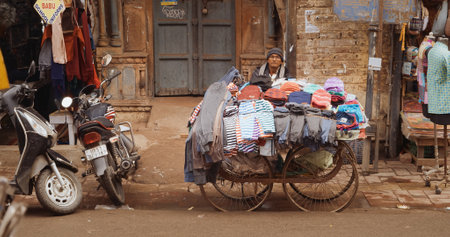 New Delhi, Delhi, India - February 04, 2024: A man sells clothes from his cart On The Main Bazar road Street Paharganj.のeditorial素材