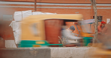 New Delhi, Delhi, India. Indian man carries loaded cargo on a cargo bike. Traffic On The Desh Bandhu Gupta road street. Cargo Lorry Trishaw pedicab moving on a bicycle along the street. Cars, Motorcycles, Auto Rickshaw Or Tuk-tuk Moving On Street In morniのeditorial素材