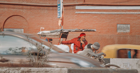 New Delhi, Delhi, India. Indian man carries loaded cargo on a cargo bike. Traffic On The Desh Bandhu Gupta road street. Cargo Lorry Trishaw pedicab moving on a bicycle along the street. Cars, Motorcycles, Auto Rickshaw Or Tuk-tuk Moving On Street In morniのeditorial素材