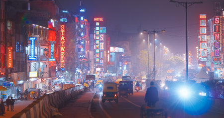 New Delhi, Delhi, India. Night Traffic On The Desh Bandhu Gupta road street. People, Cars, Motorcycles, Auto Rickshaw Or Tuk-tuk Moving On Street In night. Night view on hotels neon signs, night ad, night advertisingのeditorial素材