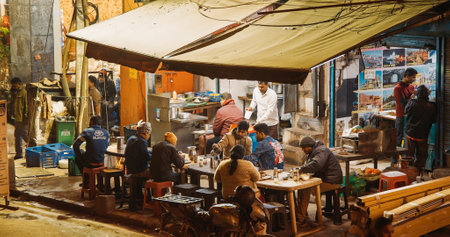 New Delhi, Delhi, India. Indian people having dinner in an evening street cafeのeditorial素材