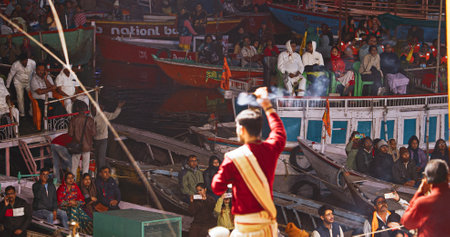 Varanasi, Uttar Pradesh, India. Brahman priest wearing red and yellow dress doing traditional ganga aarti at ghat, Varanasi, Uttar Pradesh, India Puja ritual in Varanasi. Close upのeditorial素材
